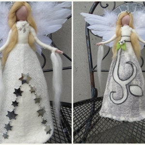 Op de afbeelding: Handgemaakte engelenpoppen met witte gevederde vleugels en lang blond haar. De ene pop heeft een witte jurk met zilveren steraccenten, de andere een grijze jurk met een wit ontwerp. Beide poppen hebben lange witte linten.
