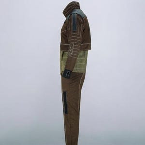 Puede incluir: Mono marr&oacute;n y verde oliva con cuello alto y mangas largas. La chaqueta tiene detalles en negro y costuras blancas. Los pantalones tienen un detalle negro en el lateral y un pu&ntilde;o negro en el tobillo. El mono est&aacute; hecho de un material suave.