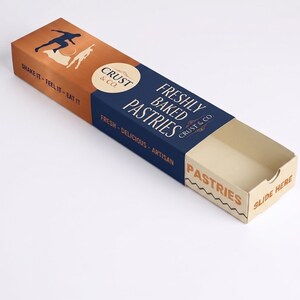 May include: A rectangular cardboard pastry box with a sliding tray. The sleeve is dark blue and copper-colored, featuring the text "CRUST & CO. FRESHLY BAKED PASTRIES," "SHAKE IT - FEEL IT - EAT IT," and "FRESH - DELICIOUS - ARTISAN." The tray says "PASTRIES" and "SLIDE HERE."