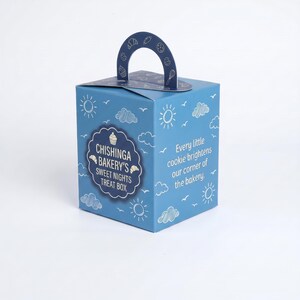 May include: A blue square treat box with a handle, featuring white line drawings of suns, clouds, and baked goods. The text reads: CHISHINGA BAKERY'S SWEET NIGHTS TREAT BOX and Every little cookie brightens our corner of the bakery. The box is upright.