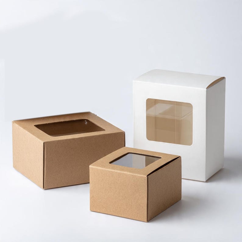 Pu&ograve; includere: Tre scatole rettangolari e quadrate con finestre in plastica trasparente. Una scatola &egrave; bianca e alta, mentre le altre due sono in carta kraft marrone. Le scatole presentano un semplice design pieghevole con un'apertura trasparente frontale.