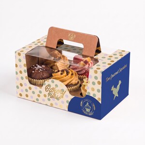 May include: A rectangular cardboard bakery box with a handle and a clear plastic window displaying four cupcakes. The box features a cream background with multicolored polka dots, blue side panels, and the text Bakery House and Two Gourmet Cupcakes.