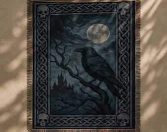 May include: Dark blue woven throw blanket featuring a raven perched on a tree branch under a full moon. The design includes a castle silhouette, skulls, and Celtic knot borders. The blanket has a fringed edge.