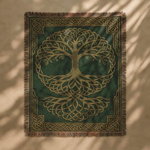 May include: A green throw blanket with a gold Celtic tree of life design. The tree is centered on the blanket, surrounded by a gold border with Celtic knot patterns. The blanket has a fringed edge.