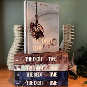 K&ouml;nnte beinhalten: Eine Sammlung von B&uuml;chern mit dem Titel "The Debt of Time" von Shaya Lonnie. Die Einb&auml;nde zeigen ein Vintage-Uhrendesign und einen Farbverlauf in Braun, Blau und Grau. Die B&uuml;cher sind gestapelt und aufrecht.