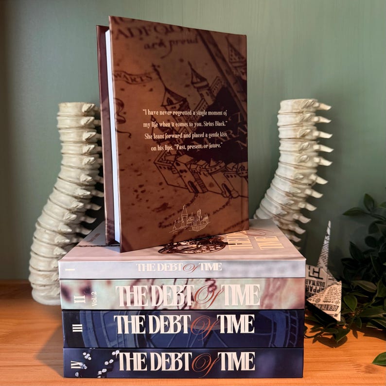 K&ouml;nnte beinhalten: Ein Stapel von vier B&uuml;chern mit dem Titel "THE DEBT OF TIME". Das oberste Buch ist ge&ouml;ffnet und zeigt Text und eine kartenartige Illustration. Die B&uuml;cher sind auf einer Holzoberfl&auml;che gestapelt, mit dekorativen Objekten auf beiden Seiten.