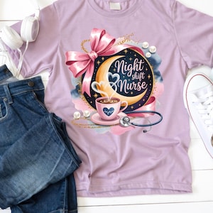 May include: A light purple t-shirt featuring a graphic design with the text "Night Shift Nurse". The design includes a crescent moon, coffee cup, stethoscope, and a pink bow. White sneakers and blue jeans are also in the image.