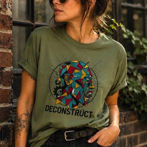 A camiseta Deconstruct apresenta um retrato cubista abstrato com formas geométricas para um visual streetwear industrial expressivo.