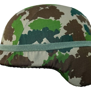 Peut inclure: Casque de camouflage aux tons de vert, marron et beige. Le casque est doté d'un bord et d'une bande au milieu. Le motif est un design militaire classique. Le casque est probablement fait d'un matériau durable.