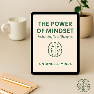 Peut inclure: Une tablette numérique affiche le texte "THE POWER OF MINDSET" avec le sous-titre "Reclaiming Your Thoughts" et un graphique de cerveau. Les mots "UNTANGLED MINDS" sont en bas. Une tasse blanche, un carnet et un stylo sont également visibles.