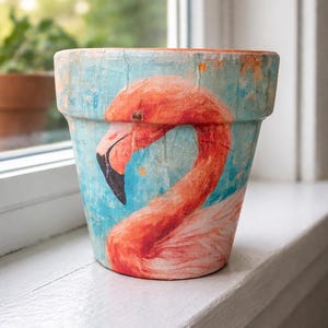 May include: A white ceramic mug with a black handle and the text "But First, Coffee" in a bold, black font. The mug is set against a blurred background, suggesting a cozy setting.