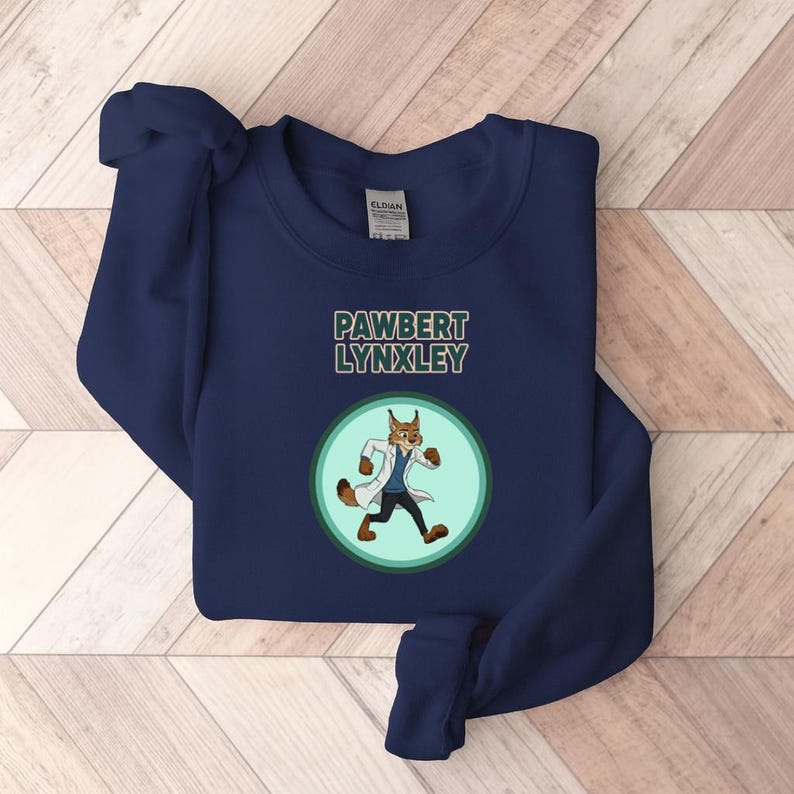 May include: Navy blue sweatshirt with the text "PAWBERT LYNXLEY" above a cartoon lynx wearing a lab coat. The lynx is inside a green and light green circle. The sweatshirt is made of a soft material.