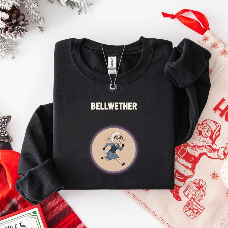May include: Black sweatshirt with the word "BELLWETHER" in white block letters. Below the text is a circular graphic of a cartoon sheep wearing glasses and a blue suit. The sheep is running. A silver necklace is visible.
