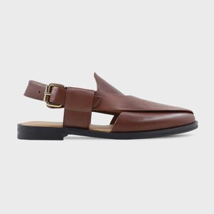 Pode incluir: Sand&aacute;lia de couro castanho com um design &uacute;nico. Apresenta bico fino, uma tira com fecho de fivela e um detalhe distinto em forma de barbatana na parte superior. A sola &eacute; preta e a sand&aacute;lia tem uma est&eacute;tica minimalista.