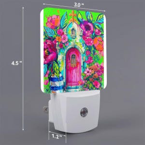 May include: A white plug-in night light featuring a rectangular panel with a vibrant, colorful illustration of a pink door surrounded by bright flowers and green foliage. The panel measures 3.0 inches wide by 4.5 inches high, with a 1.2 inch depth.