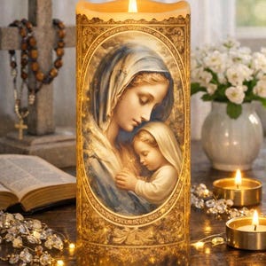 Può includere: Una candela decorativa con una calda luce, con un ritratto ovale di una madre e un bambino. La candela ha una cornice dorata ed è circondata da altre candele, una croce e un rosario.