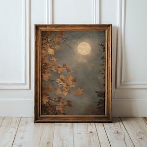 Può includere: Una stampa artistica rettangolare da parete in una cornice di legno marrone scuro che raffigura un dipinto di una luna piena in un cielo notturno nuvoloso, con foglie d'acero marrone dorato su rami a sinistra e sagome di alberi scuri a destra.