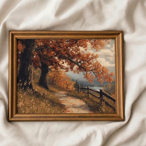 May include: A framed landscape painting depicting an autumn scene with vibrant orange and red foliage on large trees, a winding dirt path covered in fallen leaves, a wooden fence, and a distant view of a lake under a cloudy sky.