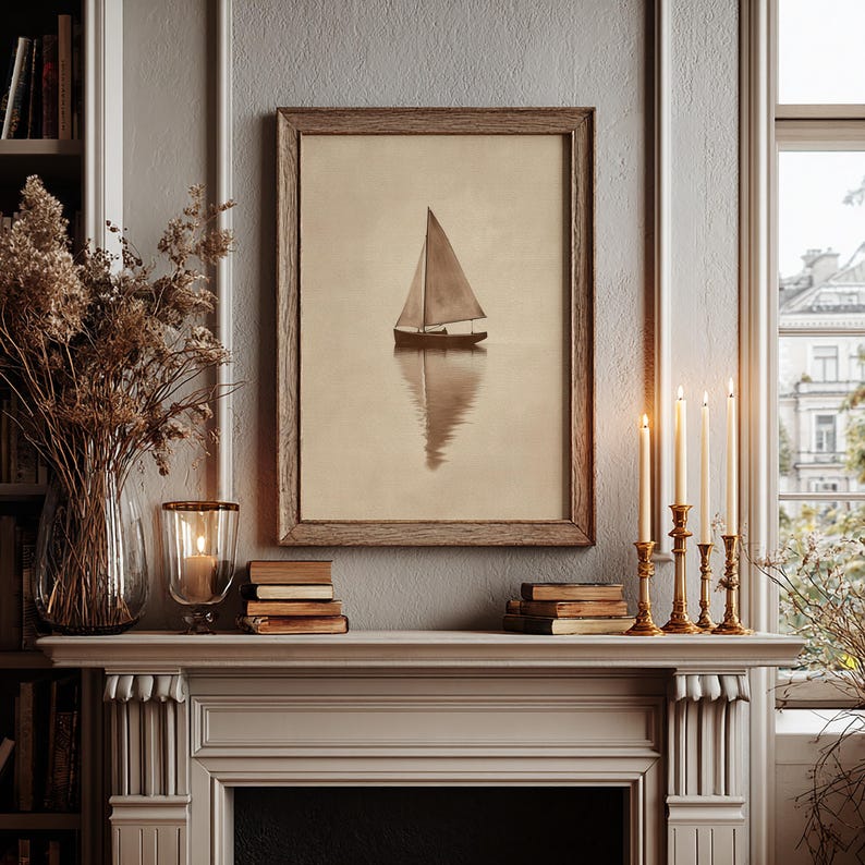 May include: A framed sepia-toned print of a sailboat on calm water. The artwork is displayed above a white mantelpiece, alongside lit candles in gold candlesticks, books, and a glass vase with dried flowers. The scene evokes a sense of tranquility.