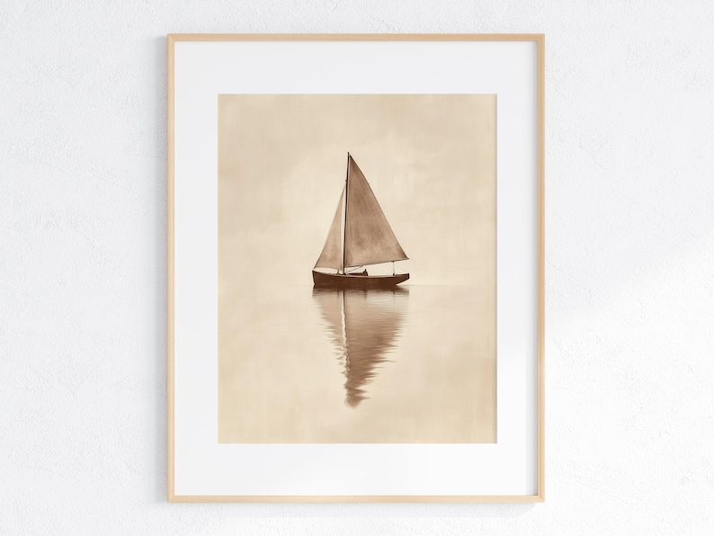 May include: A sepia-toned framed print of a sailboat on calm water. The sailboat has a triangular sail and is reflected in the water below. The artwork is in a light wooden frame, suitable for nautical or minimalist decor.