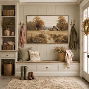 May include: A mudroom entryway featuring a built-in bench with drawers, a landscape painting of a barn in a field, two woven baskets, a floral patterned rug, olive green and cream throw pillows, a wicker basket with flowers, and rain boots.