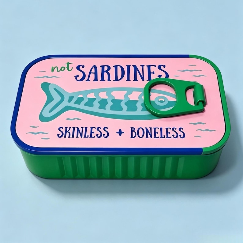 Puede incluir: Una lata rectangular verde con tapa rosa que presenta un gr&aacute;fico de pez azul y el texto "not SARDINES" y "SKINLESS + BONELESS". La tapa incluye un mecanismo de anilla verde y los lados del recipiente tienen una textura acanalada.