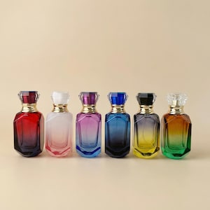 May include: Six colorful perfume bottles with jewel-like caps. The bottles are arranged in a row, each with a different color gradient, including red, pink, purple, blue, yellow, and green. The caps are faceted and have a gold-colored band.