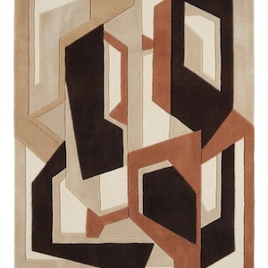 Puede incluir: Una alfombra rectangular con un patrón geométrico de formas entrelazadas en tonos marrón oscuro, terracota, beige y crema. El diseño consiste en líneas angulares nítidas y bloques superpuestos que crean una sensación de profundidad.