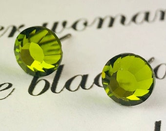 May include: A pair of small, round, green earrings. The earrings are made of glass and have a faceted design.