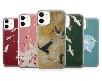 May include: A collection of five phone cases with crane designs. Each case features a different color scheme, including red, pink, gold, green, and teal. The crane illustrations vary in style, with some cases showcasing a flock of white cranes.