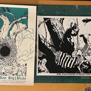 May include: Two concert posters for the bands Primitive Man and Big Brave. The Primitive Man poster is black and white and features a skeletal creature with a skull head. The Big Brave poster is white with a teal background and features a black and white illustration of a tree with a hole in the trunk.