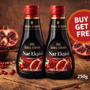 Könnte beinhalten: Zwei Flaschen Nar Ekşisi Granatapfel-Sauersauce mit roten Verschlüssen und schwarzen Etiketten, mit Granatapfel-Illustrationen. Ein "Kaufe 1, erhalte 1 gratis"-Schild ist sichtbar. Die Flaschen sind jeweils 250g.