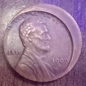 Op de afbeelding: Een koperkleurige 1909 S Lincoln cent munt. De voorzijde toont een profiel van Abraham Lincoln, de woorden "IN GOD WE TRUST" en "LIBERTY". Het jaartal "1909" is ook zichtbaar.