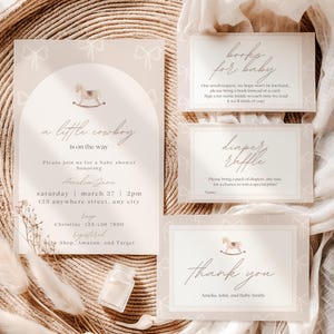 May include: A baby shower invitation suite with a cowboy theme. The invitation features the text "a little cowboy is on the way." Additional cards include "books for baby," "diaper raffle," and "thank you." The design is in neutral tones.