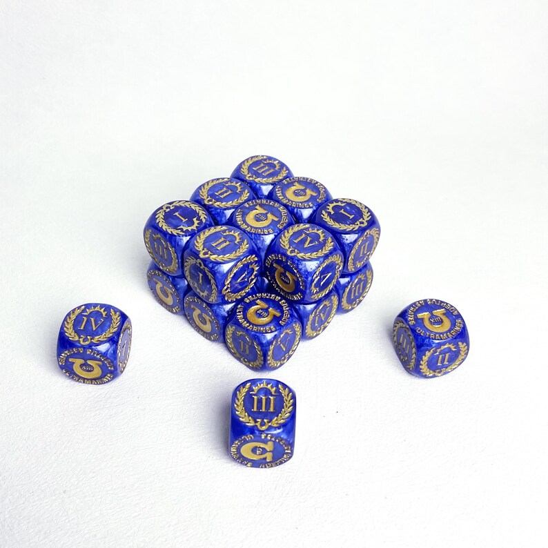 May include: A collection of blue dice with gold markings, arranged in a cube shape. Each die features Roman numerals and decorative emblems. The dice are set against a white background, highlighting their detailed design.
