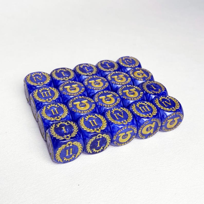May include: A collection of blue dice with gold markings. Each die features Roman numerals and a laurel wreath design. The dice are arranged in a grid pattern, showcasing their detailed craftsmanship and vibrant color.