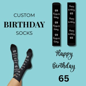 Pode incluir: Meias pretas com o texto "Happy Birthday 65" repetido em branco. A imagem também mostra as palavras "Custom Birthday Socks" e "Happy Birthday 65" em uma fonte de script em um fundo azul claro.