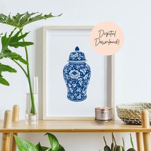 Pode incluir: Um jarro de gengibre de porcelana azul e branco com desenhos florais. O jarro está sentado em uma prateleira de madeira com uma vela e uma cesta tecida.