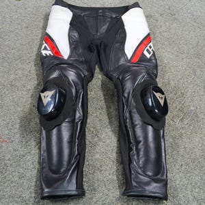 Może przedstawiać: Czarne i białe sk&oacute;rzane spodnie motocyklowe z czerwonymi akcentami. Spodnie mają ochraniacze kolan i logo na ochraniaczach kolan. Białe panele znajdują się na g&oacute;rnej części ud, a konstrukcja jest ze sk&oacute;ry.