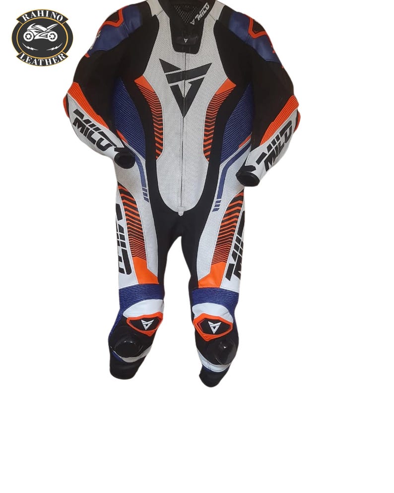May include: A multi-coloured leather motorcycle racing suit in black, white, blue, and orange. The suit has a white central panel with a black triangle logo and the word "MILU" on the arms and legs. It features a full-length zip and is designed for protection.
