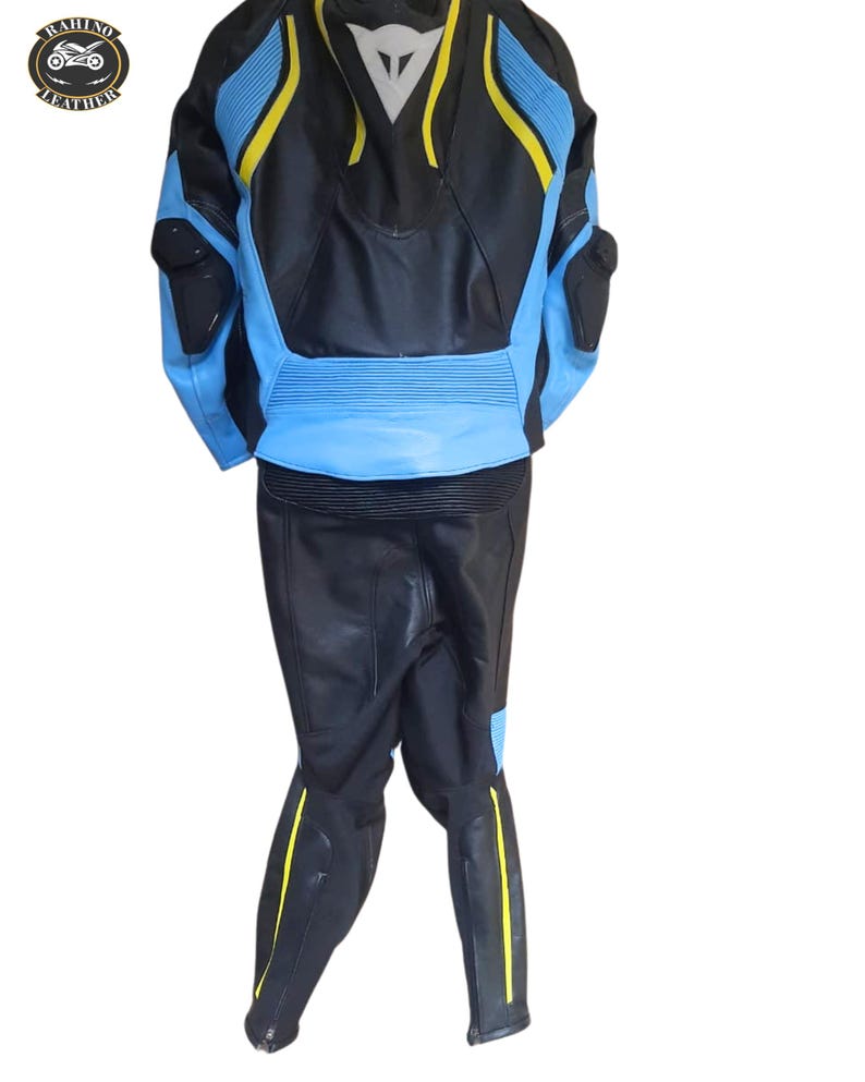 May include: Black and blue motorcycle racing suit with yellow accents. The suit features a leather jacket and pants. The jacket has blue panels on the shoulders and sides, with yellow stripes. The pants have yellow stripes down the sides.