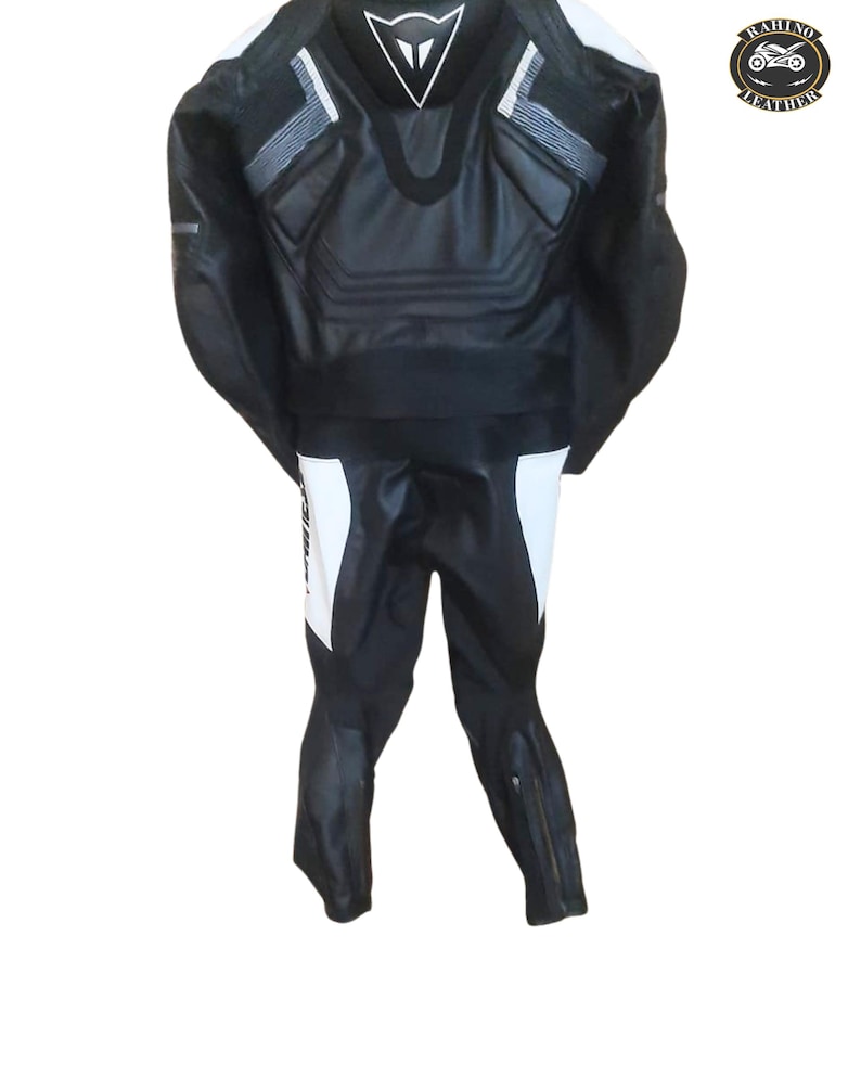 Puede incluir: Una taza de cer&aacute;mica blanca con asa negra y el texto "But First, Coffee" en negrita negra. La taza se encuentra sobre un fondo borroso, sugiriendo un ambiente acogedor.