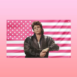 May include: A flag featuring the American flag design in pink and white, with a man in a black leather jacket. The man is leaning on the flag, with a serious expression. The background is a gradient of pink.