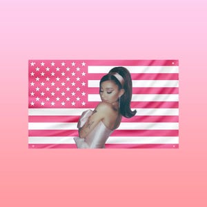 Peut inclure: Un drapeau américain rose avec des rayures et des étoiles blanches. Une femme aux cheveux foncés et vêtue d'une robe rose se tient devant le drapeau. Le fond est un dégradé de rose.