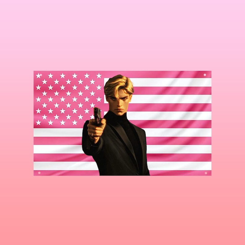 May include: A rectangular wall banner featuring a stylized illustration of a person with blonde hair wearing a black turtleneck and blazer, holding a handgun pointed forward. The background is a pink and white version of the American flag.