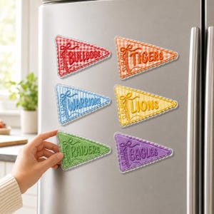 May include: Six triangular pennant magnets with a gingham pattern and scalloped edges. The magnets feature the text Bulldogs in red, Tigers in orange, Warriors in blue, Lions in yellow, Raiders in green, and Eagles in purple, each with a ribbon graphic.