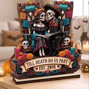 Op de afbeelding: Een decoratief beeldje met twee skeletfiguren in traditionele kleding, zittend op een houten bank. De basis toont de tekst "TILL DEATH DO US PART" en "EST. 2016". Het tafereel is versierd met kleurrijke bloemen, schedels en slingers.