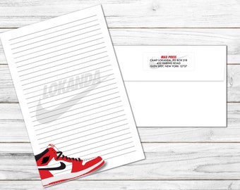 May include: A white sheet of lined paper with a gray Nike swoosh logo and a red and white basketball shoe at the bottom. The paper is labeled "MAX PRESS" with an address in Glen Spey, New York.