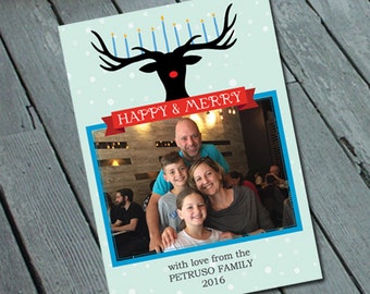 May include: A blue and white holiday card with a black silhouette of a reindeer with a red nose and blue candles on its antlers. The card has a photo of a family of four in front of a brick wall. The text on the card reads "Happy & Merry" and "with love from the PETRUSO FAMILY 2016".