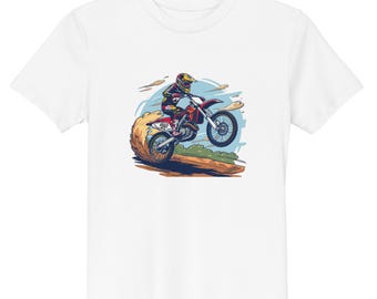 May include: A white short-sleeve t-shirt featuring a graphic illustration of a motocross rider on a red dirt bike performing a jump. The rider wears a yellow helmet and protective gear, with dust clouds kicking up from the rear tire on a dirt track.